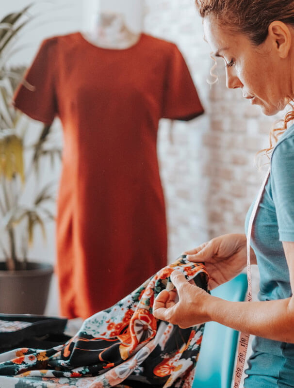 A women creating a garment out of flowered material