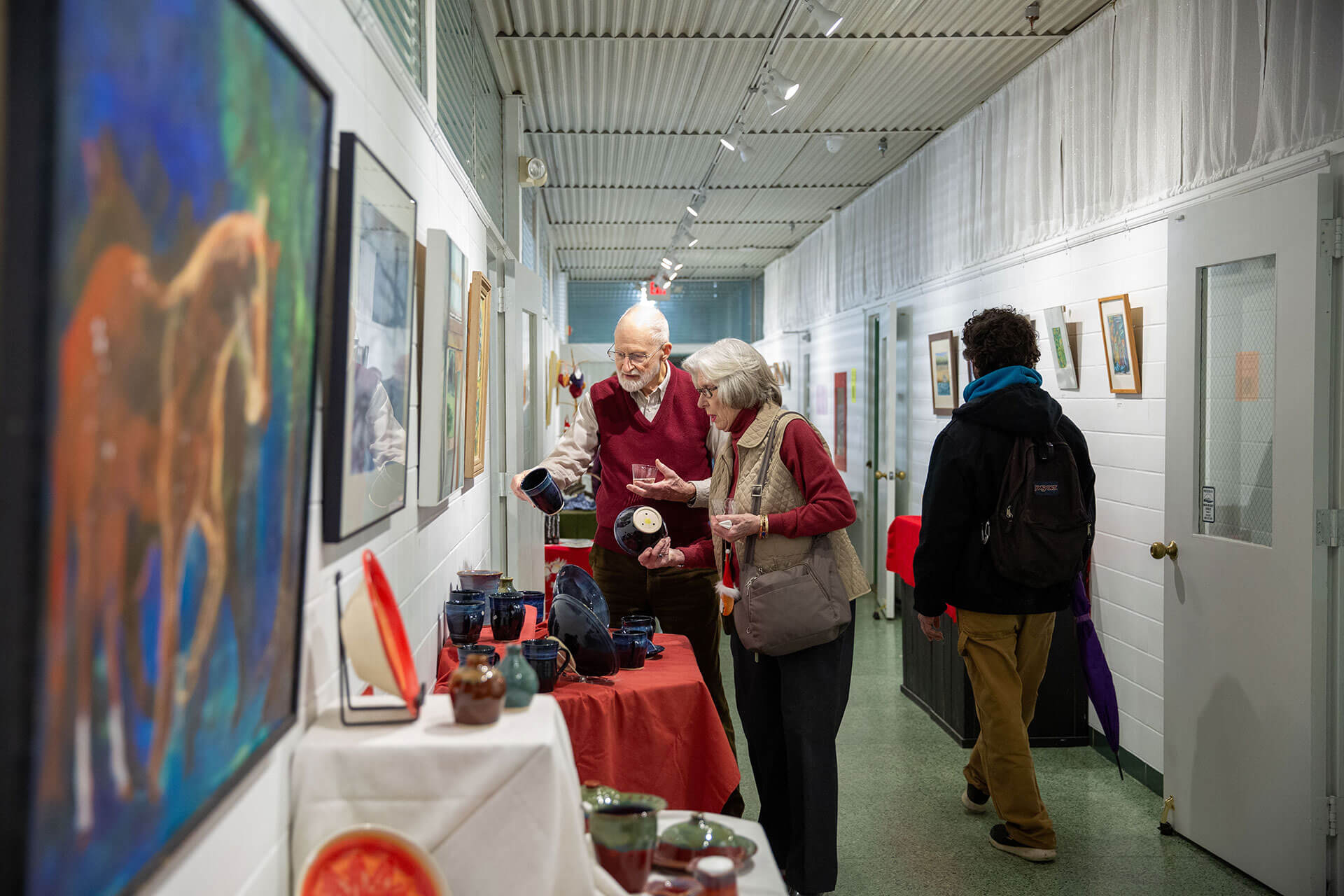 An elderly couple view artwork at T.W. Wood Museum